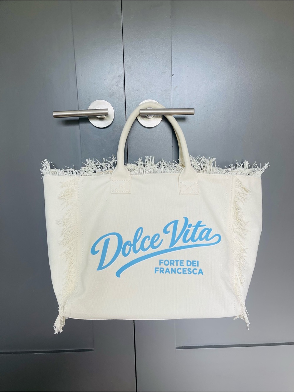 Dolce Vita Cream Canvas Fringe Tote with Light Blue Logo